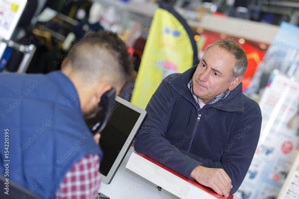 salesman serving customer in boutique salesman serving customer in boutique