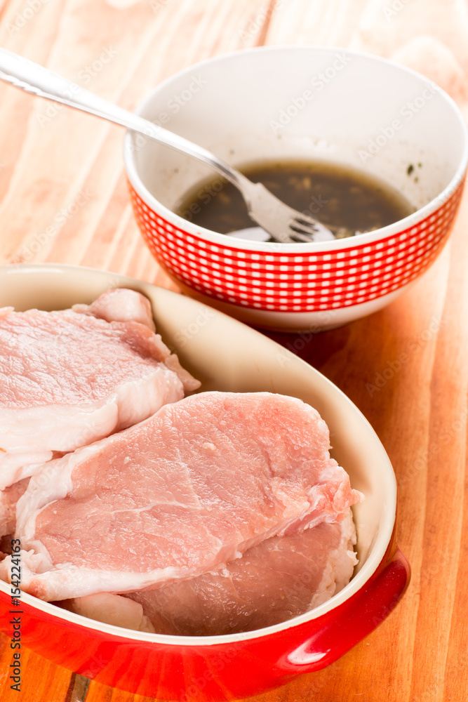 Selective focus on pork chops with barbecue marinade in the back Selective focus on pork chops with barbecue marinade in the back