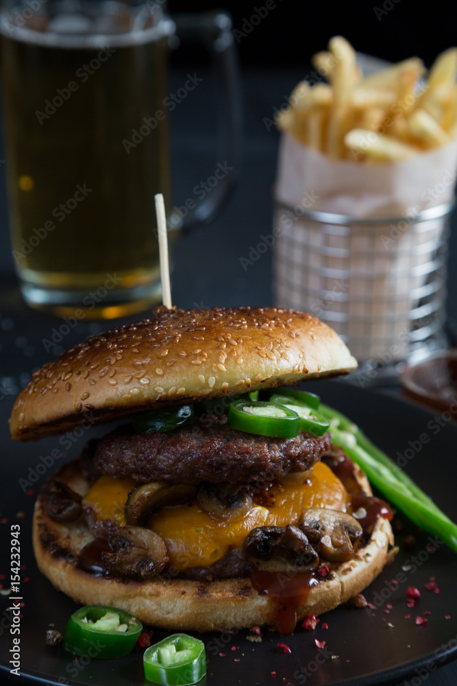 Cheeseburger with jalapeno pepper, French fries and beer Cheeseburger with jalapeno pepper, French fries and beer