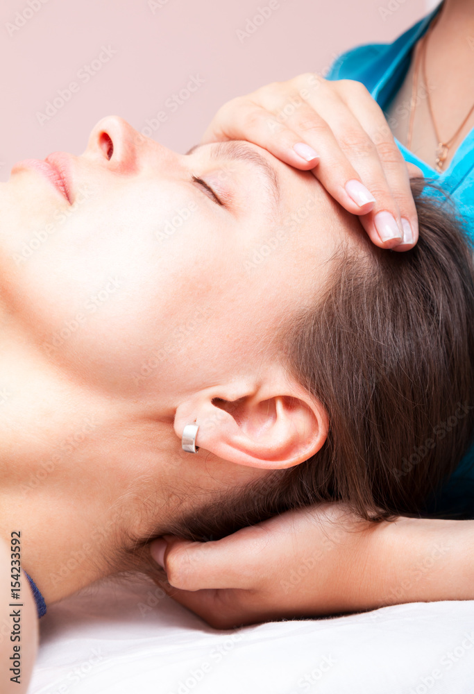 Woman receiving osteopathic treatment of her head