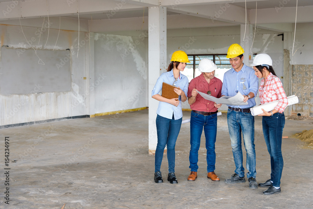 Group of Multiethnic engineers meeting about their project in construction site. Engineer subordinate and sale representor point to their project for present to engineer leader. Group of Multiethnic engineers meeting about their project in construction site. Engineer subordinate and sale representor point to their project for present to engineer leader.