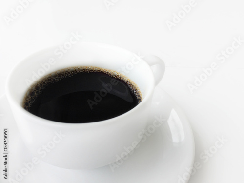 side view of black coffee in a cup of coffee on white background