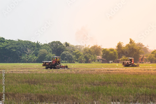 agriculture farmland,tractor with plough ploughing a soil field © saelim