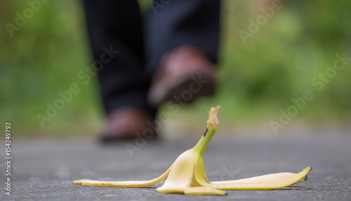 Cuadro en lienzo eine Bananenhaut liegt auf dem Gehweg, ein Mann läuft direkt darauf zu