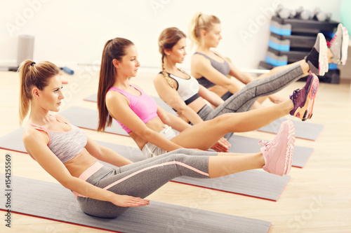 Young women doing sit-ups in a gym