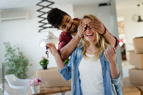 Young married couple with boxes and holding flat keys