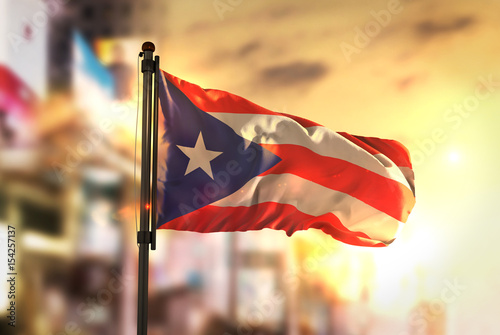 Puerto Rico Flag Against City Blurred Background At Sunrise Backlight photo