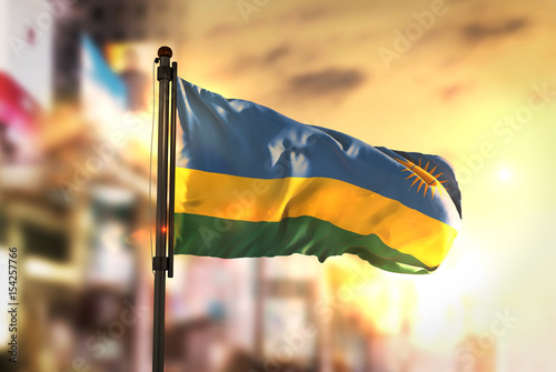Rwanda Flag Against City Blurred Background At Sunrise Backlight photo