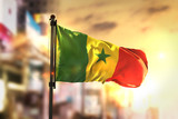 Senegal Flag Against City Blurred Background At Sunrise Backlight