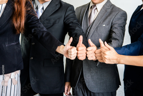 Business team showing thumbs up in office