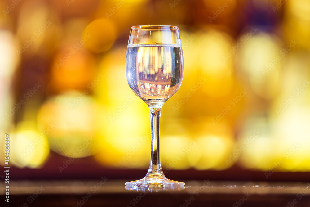 shot of vodka on the bar on a background of bright lights. shot of vodka on the bar on a background of bright lights.