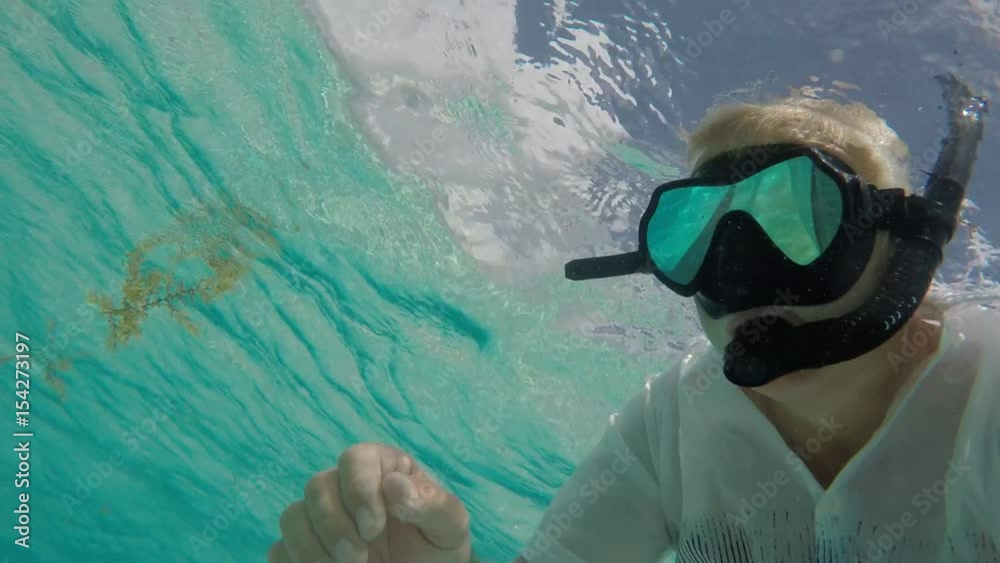 A man snorkeling in crystal clear turquoise water A man snorkeling in crystal clear turquoise water
