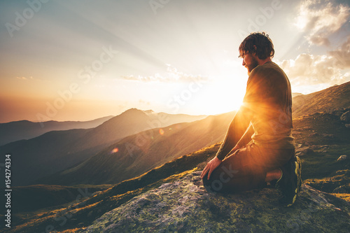 Man relaxing at sunset mountains Travel Lifestyle spiritual awakening emotional meditating concept vacations outdoor harmony with nature landscape photo