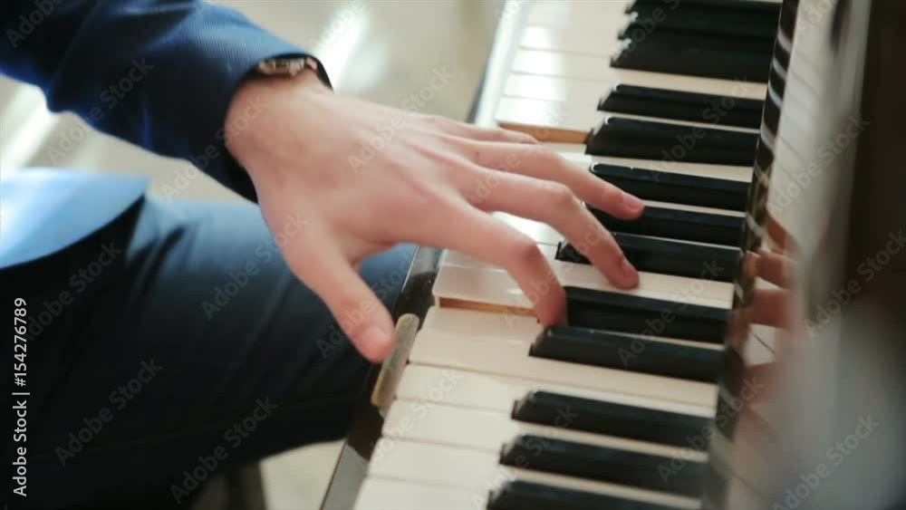 pianist in blue suit plays rapidly on the piano. top view, close up, slow motion. pianist in blue suit plays rapidly on the piano. top view, close up, slow motion.