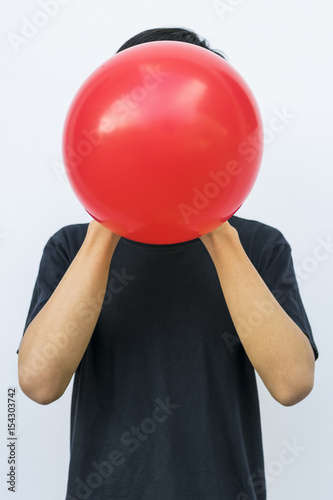 Man in black blowing red balloon