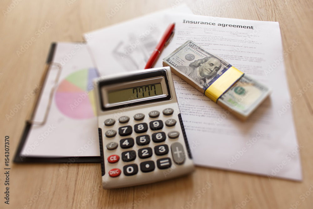 Insurance form with pen, dollars, calculator on the table. Homeowner insurance policy Insurance form with pen, dollars, calculator on the table. Homeowner insurance policy