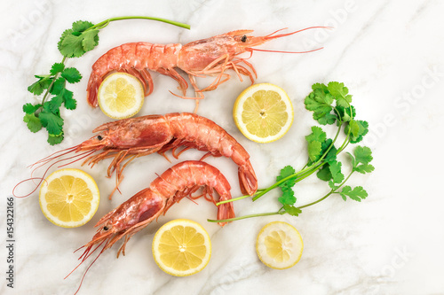 Raw shrimps with slices of lemon, cilantro, and copyspace