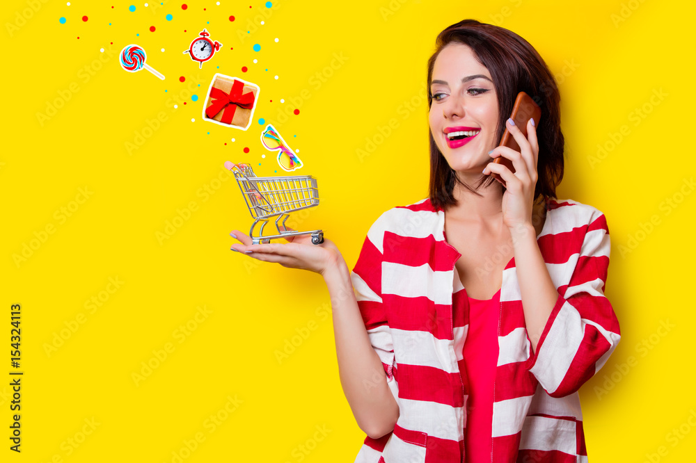 young woman with shopping cart and mobile phone young woman with shopping cart and mobile phone
