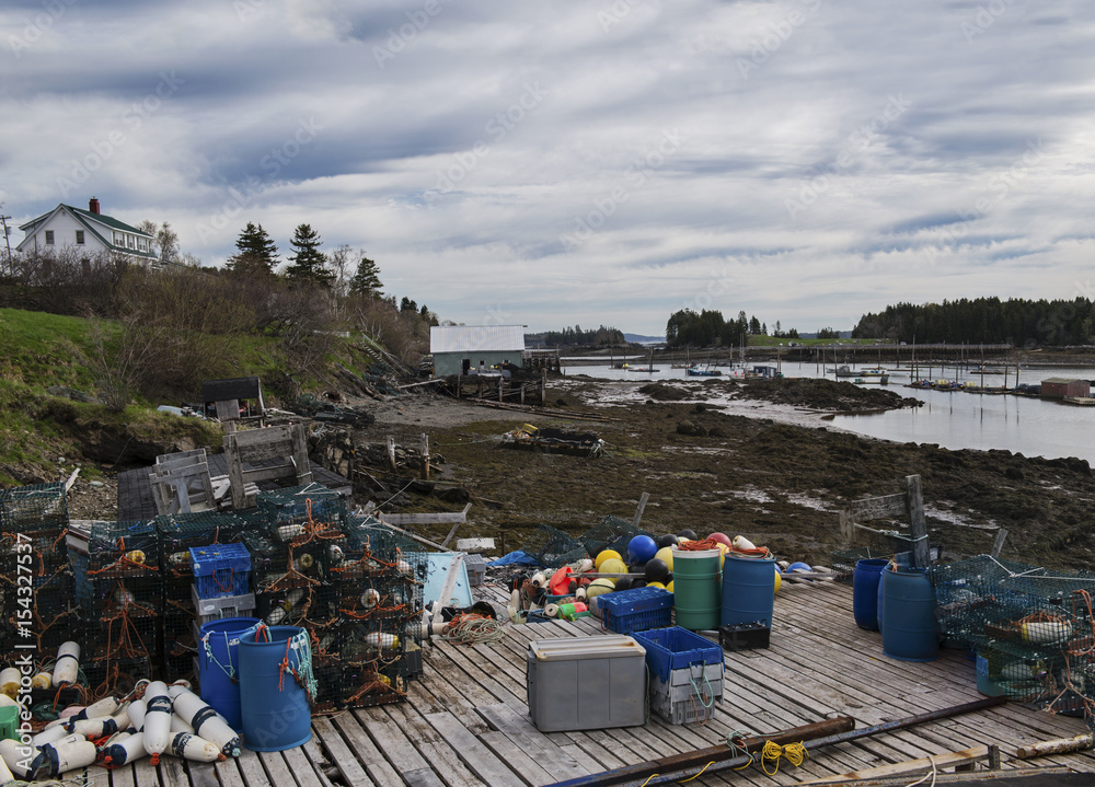 Fishing docks, and piers on Deer Island, one of the Fundy Bay Islands in Canada. Old buildings, lobster traps and buoys fill the piers and docks. Fishing docks, and piers on Deer Island, one of the Fundy Bay Islands in Canada. Old buildings, lobster traps and buoys fill the piers and docks.