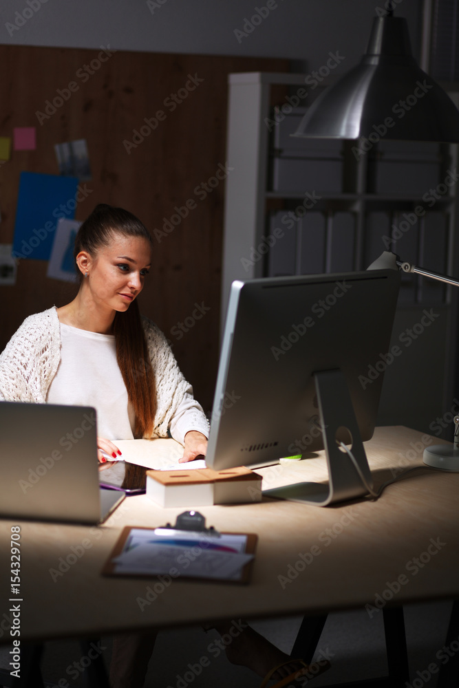 Young woman working in office, sitting at desk