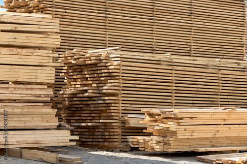 lumber, boards and beams lie in a pile at the sawmill photo