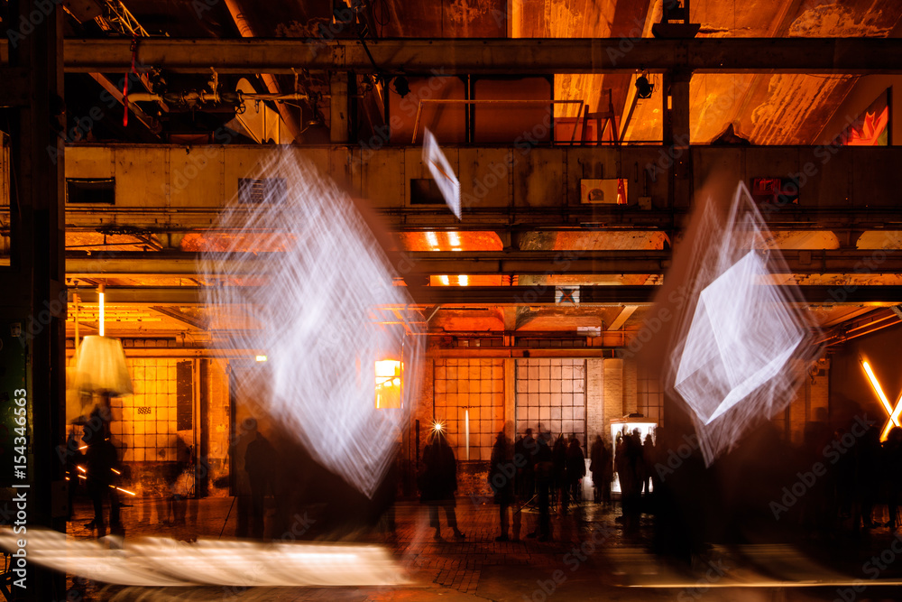 Obraz Alte Fabrikhalle mit Menschen bei Nacht mit Formen