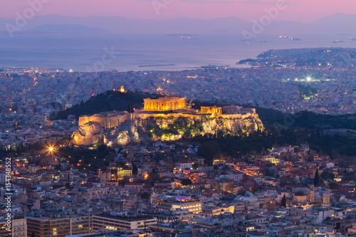 cityscape of Athens with illuminated Acropolis hill, Pathenon and sea at night, Greece
