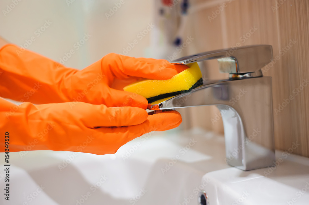 Hands in gloves with rubber cleaning bath faucet Stock Photo Adobe Stock