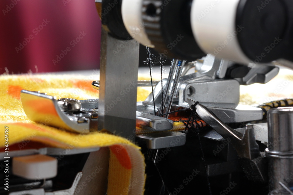 Overlock sewing machine - macro view on hook, needles and knives - foreground and background blanked ot blurry Overlock sewing machine - macro view on hook, needles and knives - foreground and background blanked ot blurry