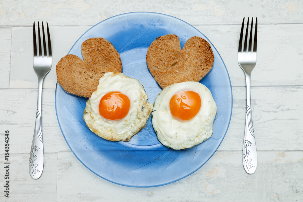 Fried eggs with toast in heart shape
