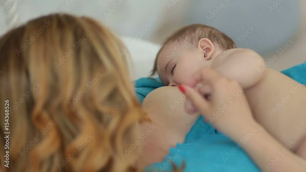 Adorable naked infant child breastfeeding Adorable naked infant child breastfeeding