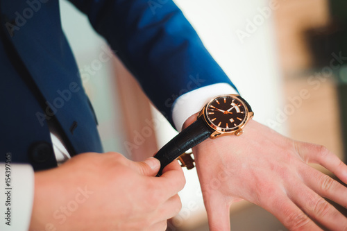 elegant businessman dressed clock before meeting with partners