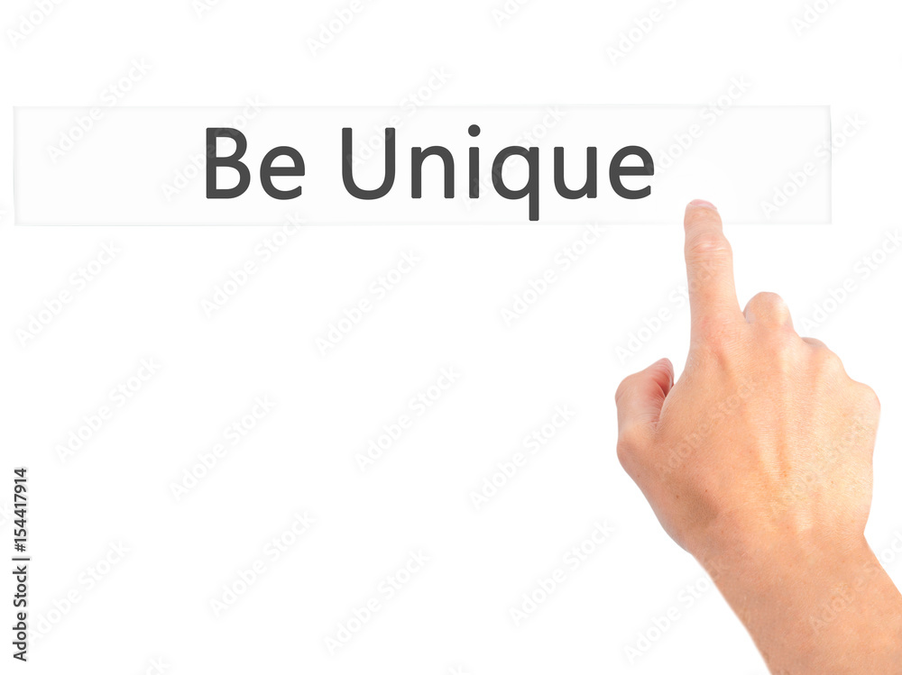 Be Unique - Hand pressing a button on blurred background concept on visual screen. Be Unique - Hand pressing a button on blurred background concept on visual screen.