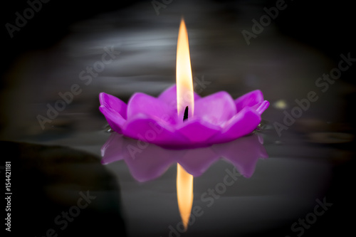 Floating flower candle in the pond with warm flame