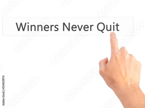 Winners Never Quit - Hand pressing a button on blurred background concept on visual screen.