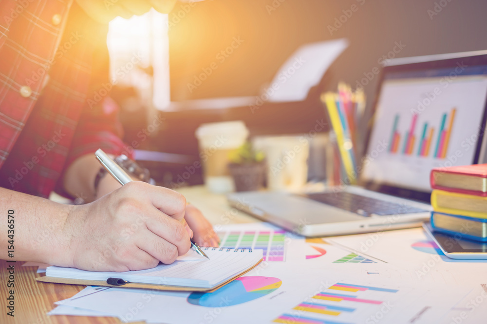 Male manager putting his ideas and writing business plan at workplace,man holding pens and papers, making notes in documents, on the table in office,vintage color,morning light ,copy space Male manager putting his ideas and writing business plan at workplace,man holding pens and papers, making notes in documents, on the table in office,vintage color,morning light ,copy space