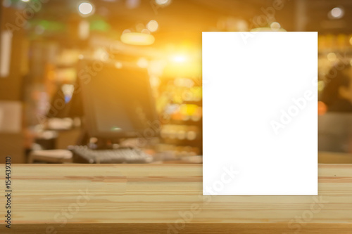 Mock up Menu frame on Table in Bar restaurant cafe,Stand for booklets with white sheets of paper acrylic table tent card mockup on wooden table on cafe teria ,can be used for montage or display photo