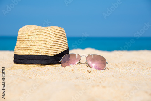 Sunglasses with hat on the beach