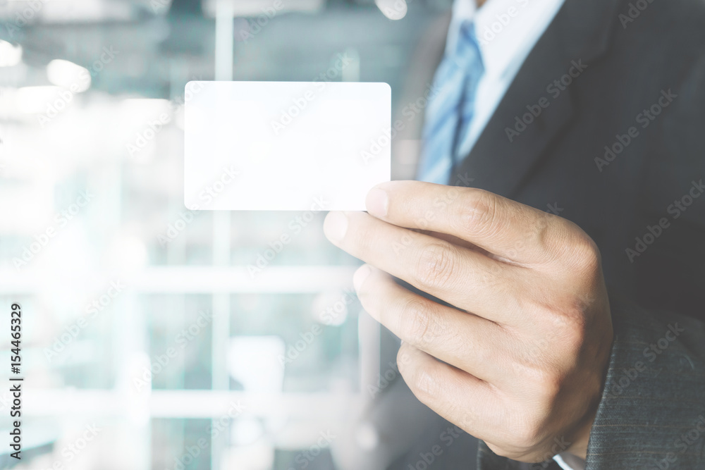 Young business man wear suit holding white business card on modern office blur background. Young business man wear suit holding white business card on modern office blur background.