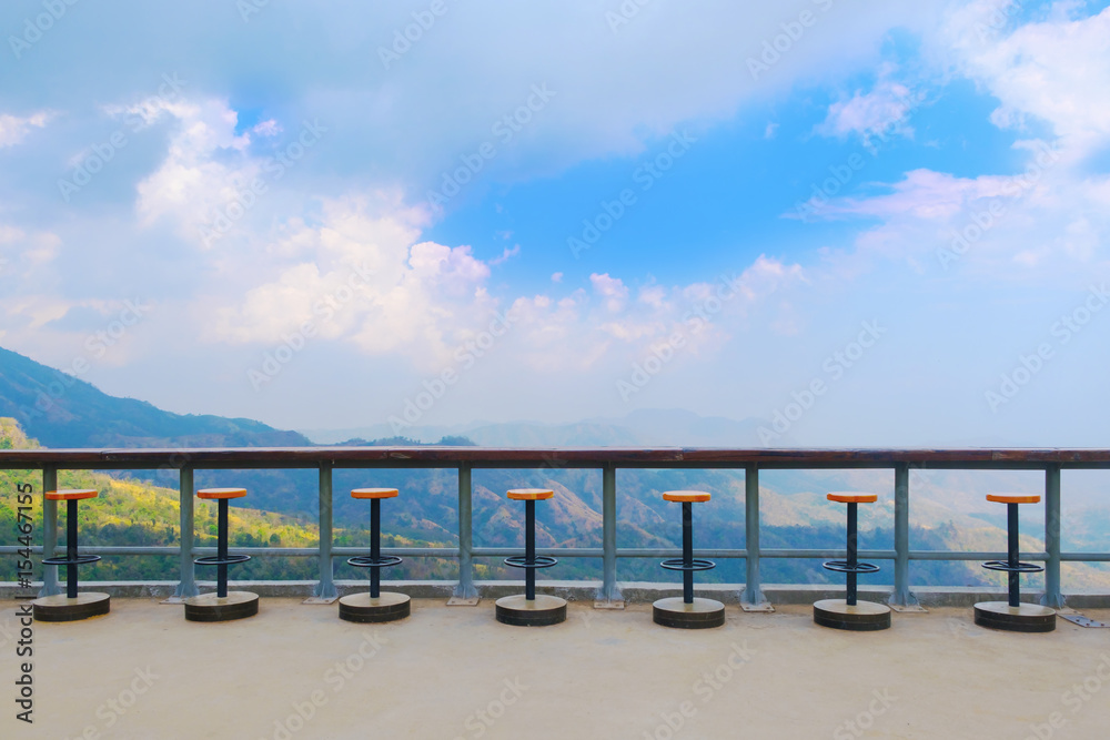 Multi steel bar chair and solid wooden desk bar on natural, blue sky, cloud background for concepts of slow life, relax and green idea.