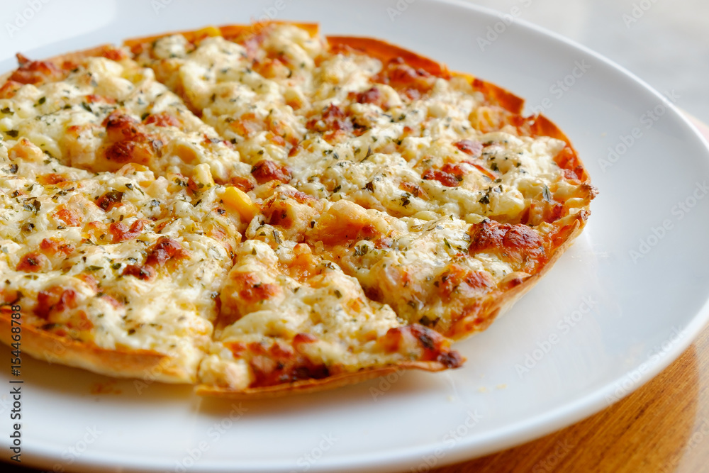 golden delicious crust pizza topped with seafood on a white plate.
