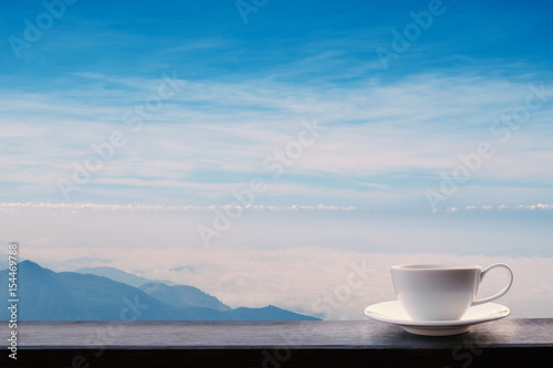 side view shot of white coffee cup on brown timber with landscape background for relax, slow life, refreshment concept.