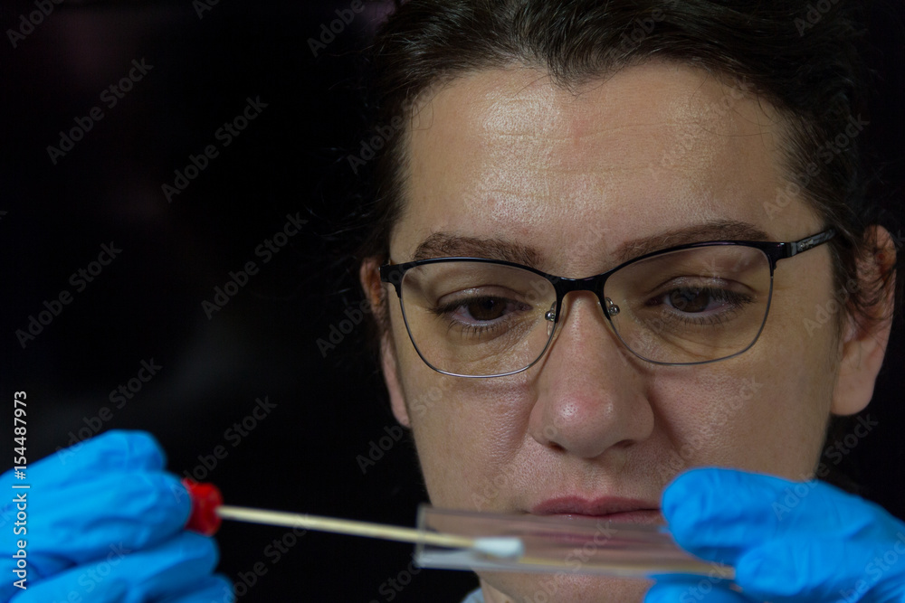 A woman collects forensic DNA sample stick A woman collects forensic DNA sample stick