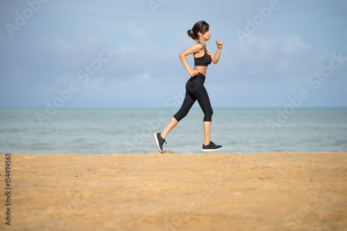 Healthy active lifestyle. Young sports fitness woman running on the beach at sunset