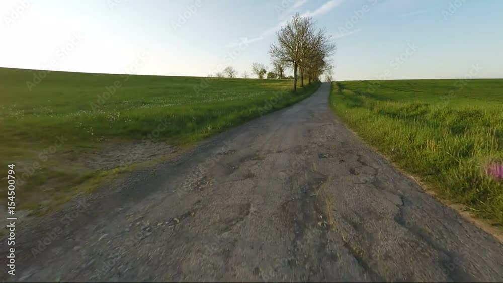 car driving in evening spring rural countryside road on a sunny day. Landscape with trees and blue sky with sunlight, travel and transportation concepts. 60 FPS POV view car driving in evening spring rural countryside road on a sunny day. Landscape with trees and blue sky with sunlight, travel and transportation concepts. 60 FPS POV view