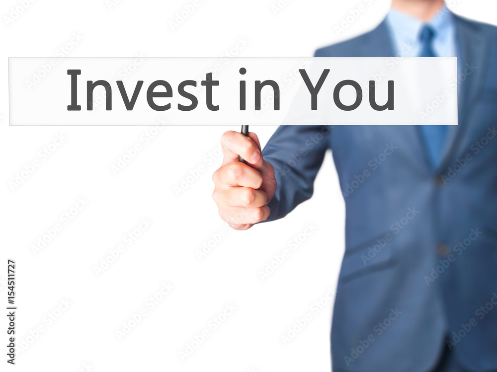 Invest in You - Businessman hand holding sign Invest in You - Businessman hand holding sign