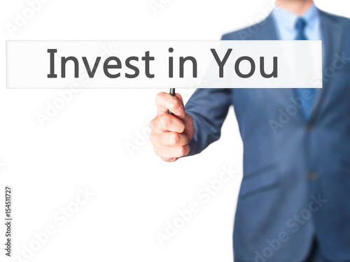 Invest in You - Businessman hand holding sign