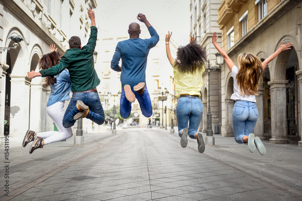 © javiindy - Group of friends jumping together outdoors