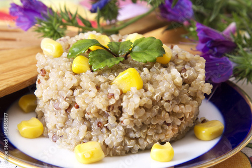 Quinoa salad with corn on plate with violet flowers photo