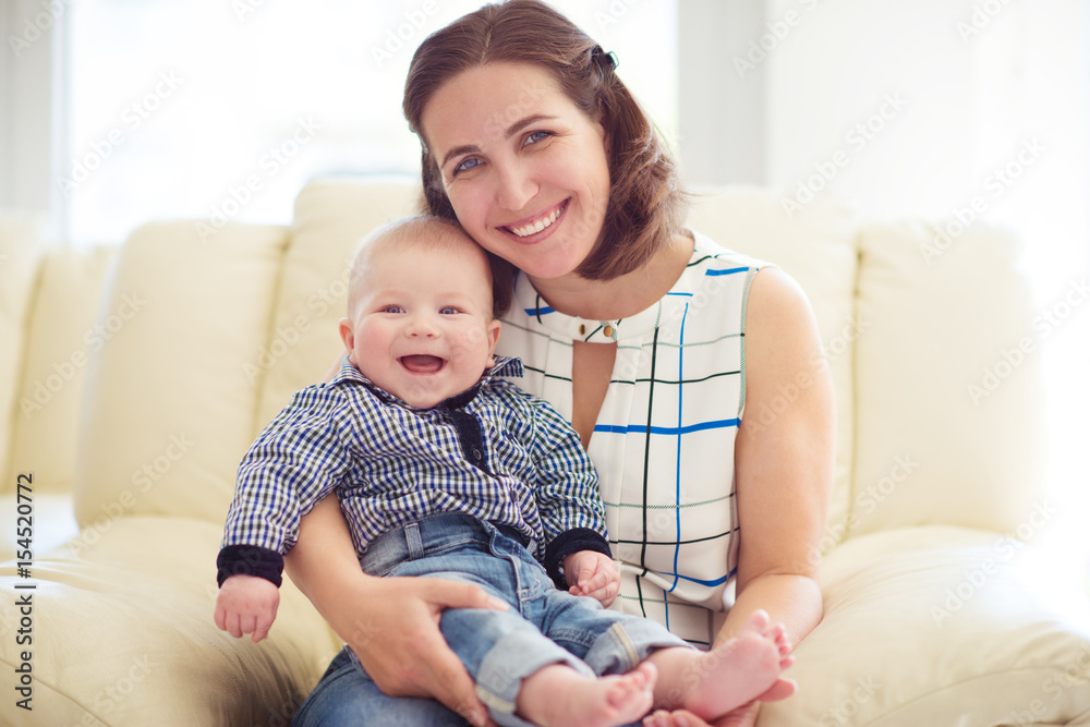 Happy mother with smiling laughing baby at home Happy mother with smiling laughing baby at home